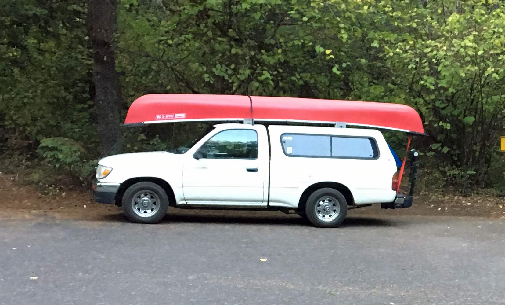 white Toyota truck with a red canoe on top