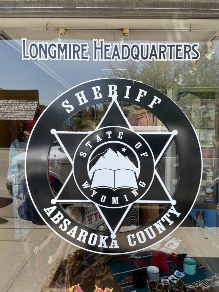 A sheriff's star reading Longmire Headquarters Sheriff Absaroka County State of Wyoming